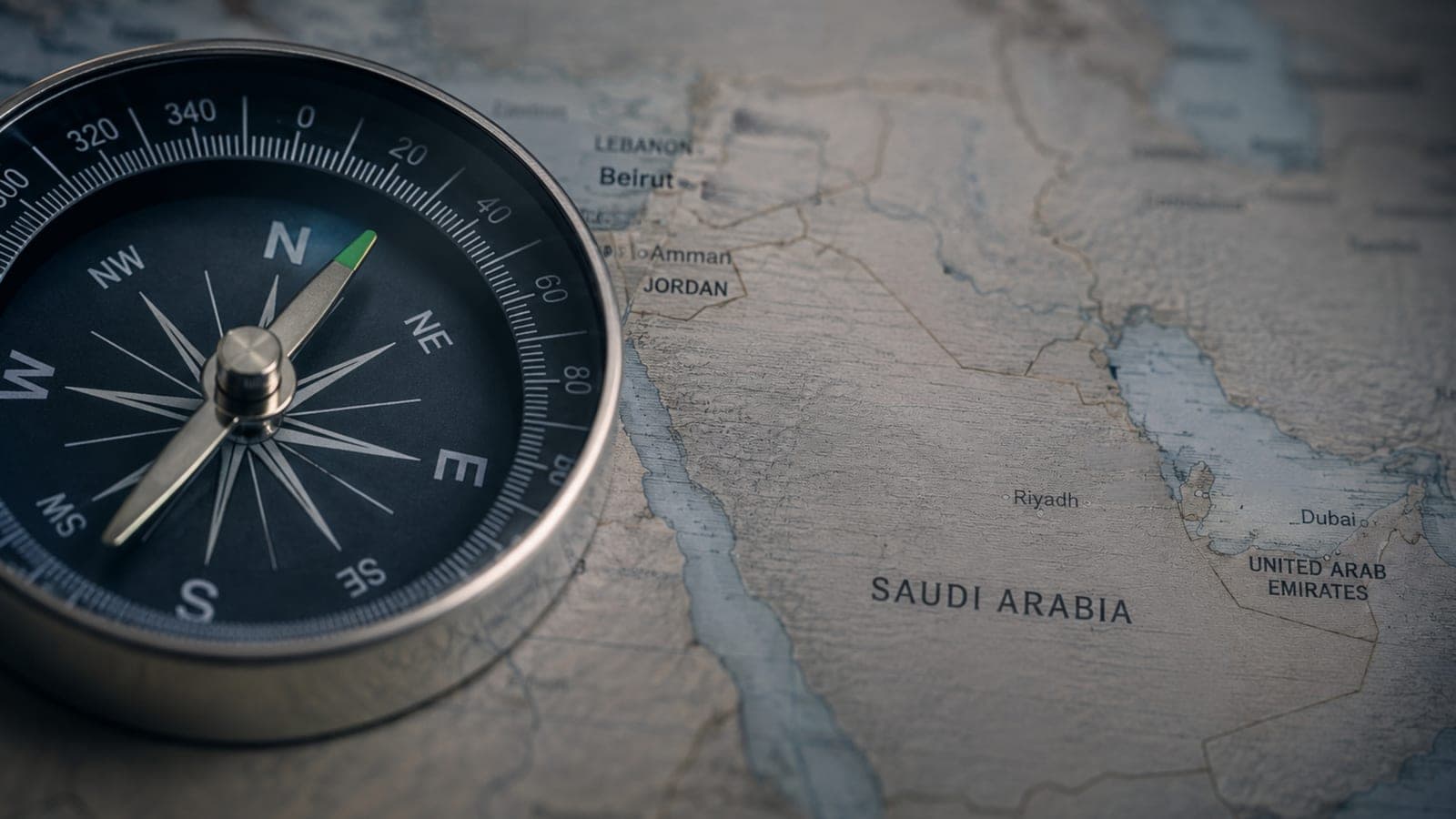 A compass resting on a map of Lebanon, Jordan, Saudi Arabia, and the UAE.